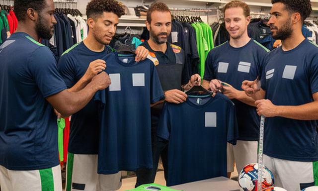 Voetbalteam dat bedrukte shirts past in een sportwinkel